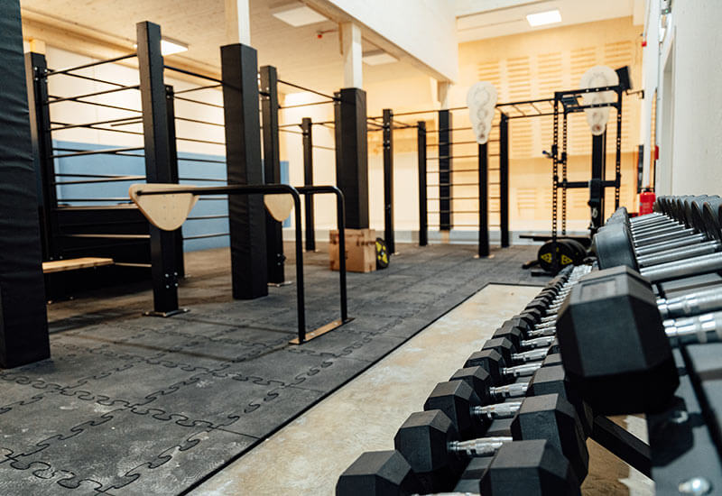 Fitnessbereich mit Fitnessrack und Kurzhanteln